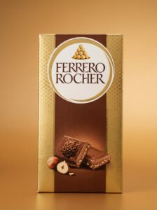 Confezione frontale tavoletta di cioccolato Ferrero Rocher con incarto dorato iconico e logo ben visibile.