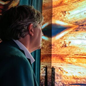 Installazione immersiva Vette e Onde: visitatrice osserva una proiezione di tramonto su barca a vela creata con AI generativa4