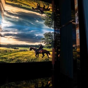 Installazione immersiva Vette e Onde: visitatrice osserva una proiezione di tramonto su barca a vela creata con AI generativa8