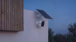 Inquadratura da telecamera di sicurezza CCTV, grandangolo, scena notturna urbana/residenziale, overlay digitale leggero da sistema di monitoraggio, estetica realistica da videosorveglianza ma con look cinematografico, luce bassa e contrastata.