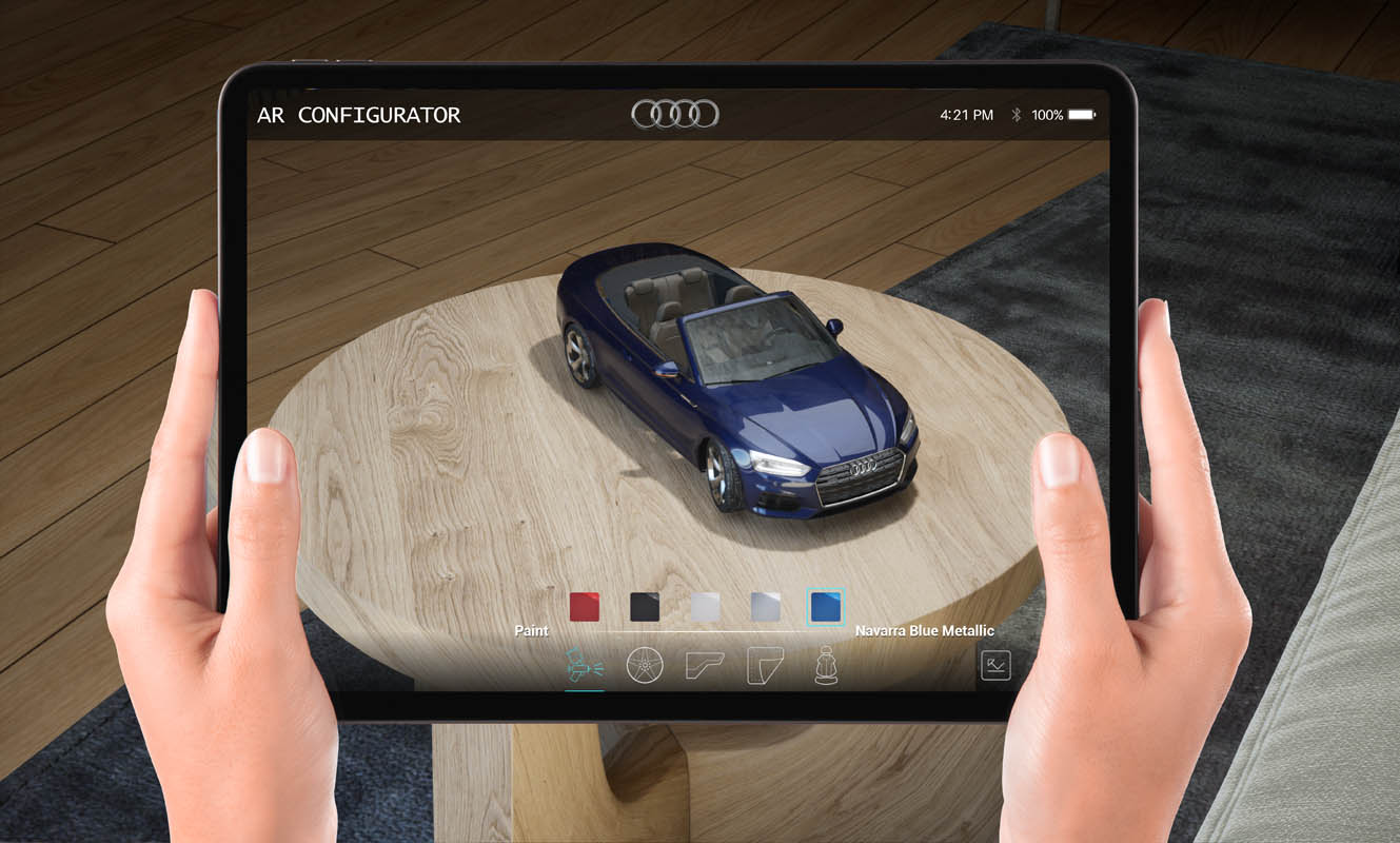 Configuratore di realtà aumentata mostrato su un tablet, con una miniatura virtuale di un’auto Audi decappottabile blu